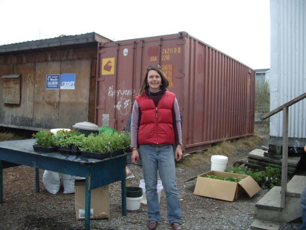 heidi with red vest and plants in front of Atco trailer